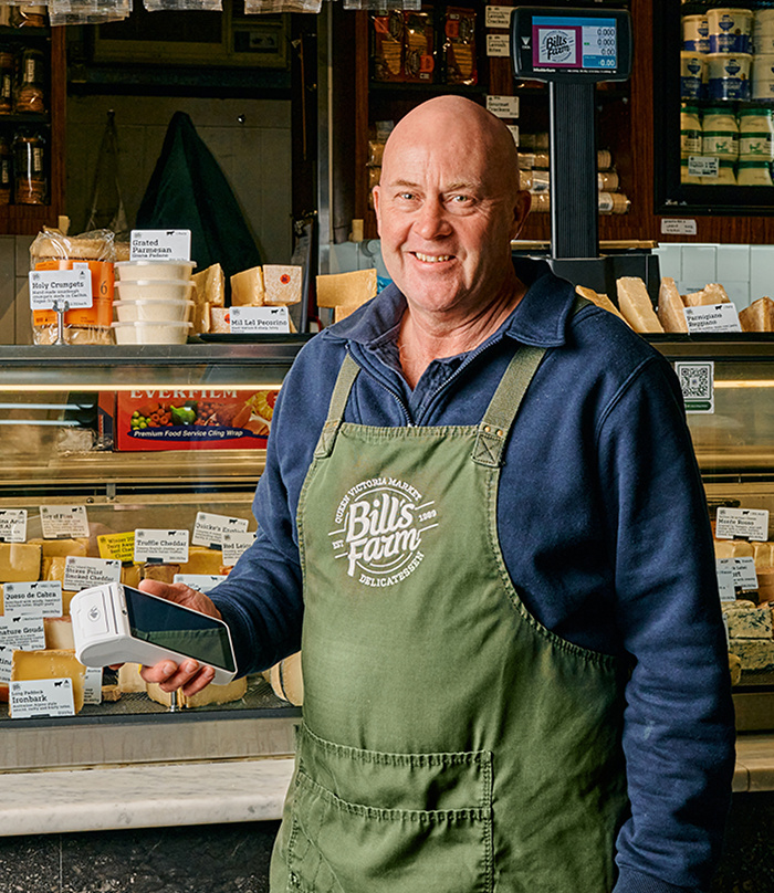 Zeller merchant Bills Farm holding a white EFTPOS machine